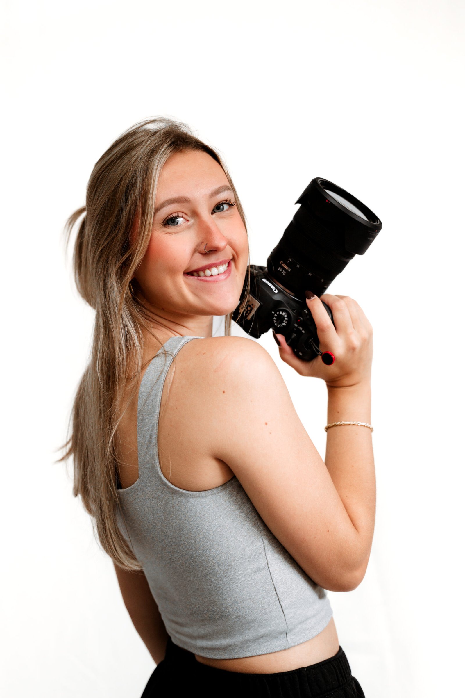 Photo of the owner, Chloe holding her camera in the studio.