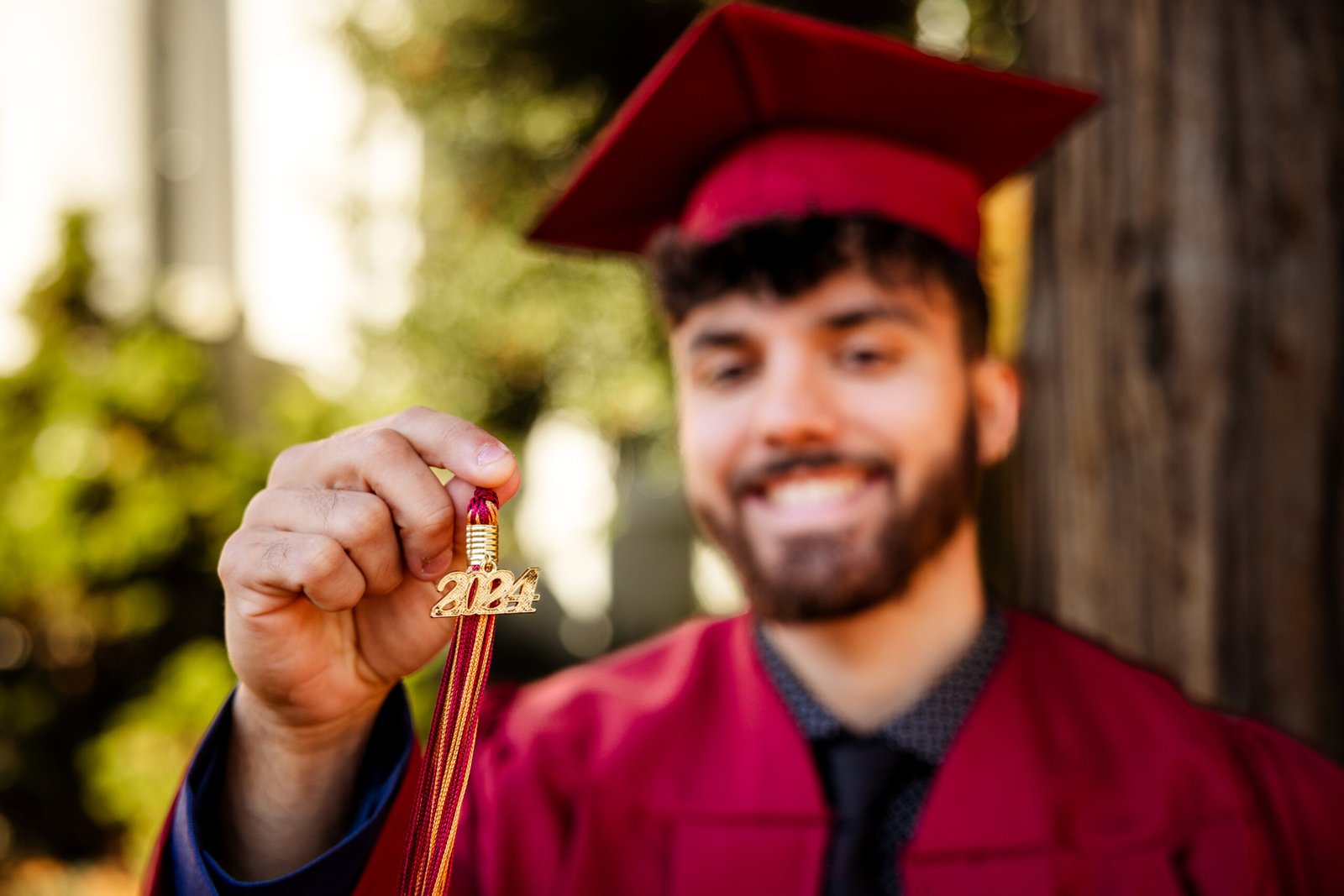 Close up of a college graduate holding up his 2024 tassel.