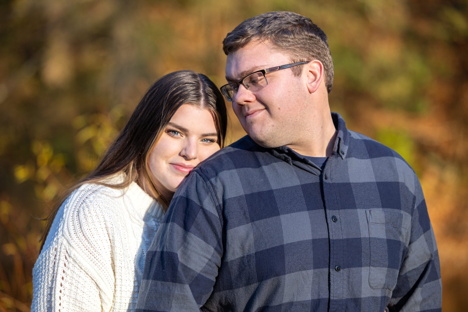 Photo of engaged couple standing outdoors infant of the pretty fall colors.