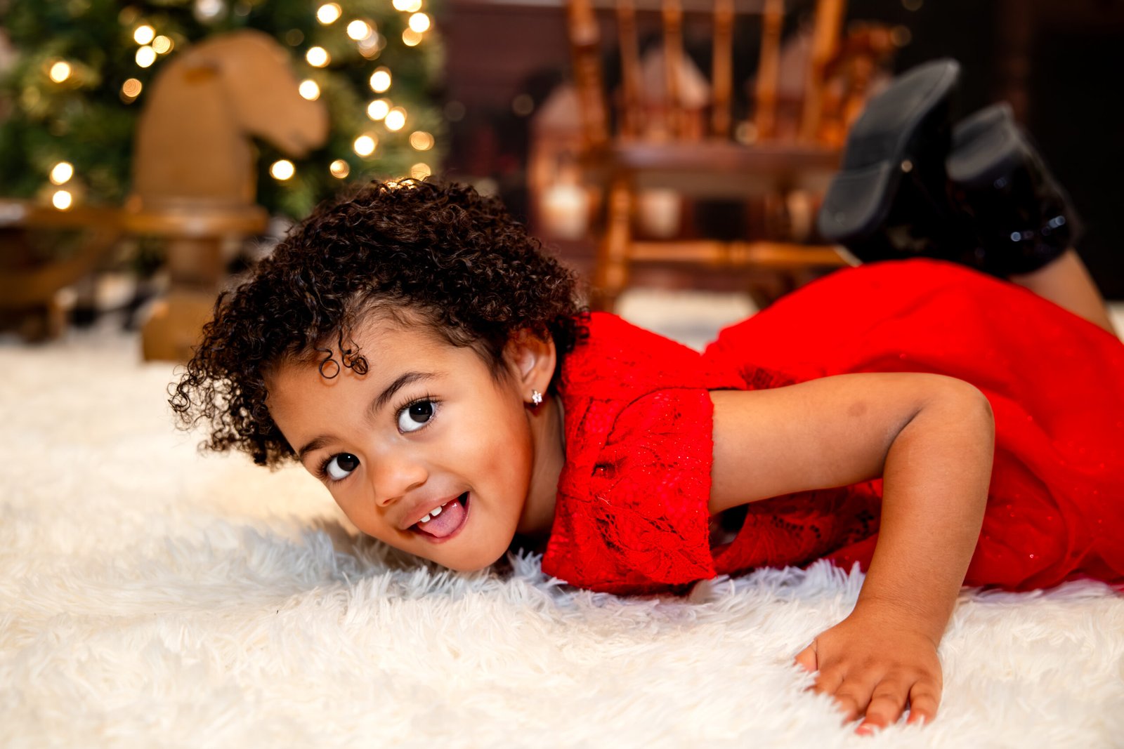 Little girl rolling around on the white carpet being silly.